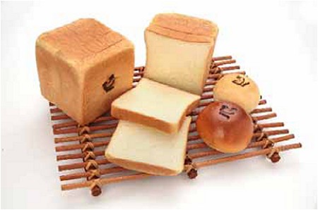 店舗で販売予定の商品の例。左から「ペコちゃんのクリーミー食パン」「ペコちゃんのあんパン」「ペコちゃんのクリームパン」。焼きインされたペコちゃんの顔が特徴。
