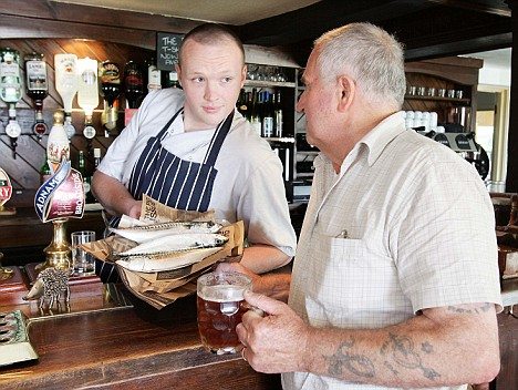 パブの料理長で店の経営者でもあるTim Abbott氏(左)と交渉中(?)のお客