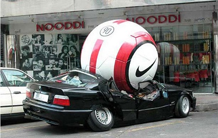 日本なら思わず110番通報したくなるようなシーン。巨大なサッカーボールが自動車を粉砕している。