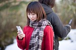 別々にケータイを使うカップルイメージ
