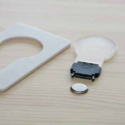 ↑ 何も無いように見える部分は、ちゃんと平たい電球のようになっている。内部にLEDライトが2つ入っていて、基部から電源用のボタン電池を入れる