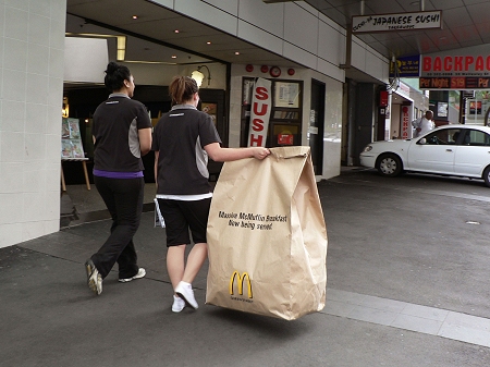 ↑ 街中をさっそうと歩く女性の手にも「マッシブマックマフィン」の袋。子供が後をつけて「でけぇよ!」というツッコミをしてきそう