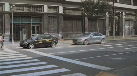 ↑ 自動車の接近に気が付く女性。黒い自動車は急ブレーキでギリギリ衝突は避けられた……